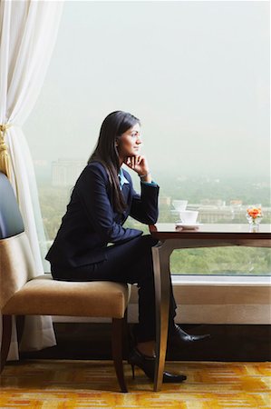 Side profile of a businesswoman sitting in an office with her hand on her chin Foto de stock - Sin royalties Premium, Código: 630-01130806