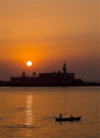 Silhouette of two people on a boat in the sea with a mosque in the background, Haji Ali Dargah, Mumbai, Maharashtra, India Foto de stock - Sin royalties Premium, Código: 630-01130859