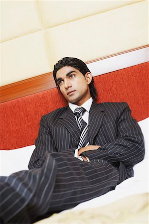 simsearch:630-02219583,k - Low angle view of a businessman reclining on the bed Stock Photo - Premium Royalty-Free, Code: 630-01130915
