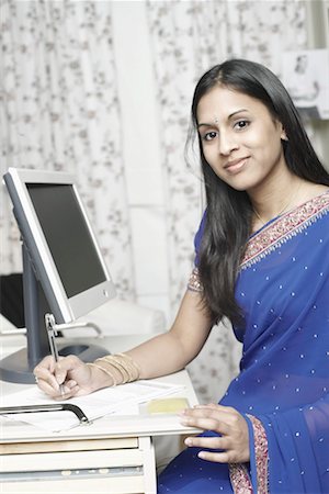 simsearch:630-01131029,k - Portrait of a young woman sitting in front of a computer monitor Foto de stock - Royalty Free Premium, Número: 630-01130927