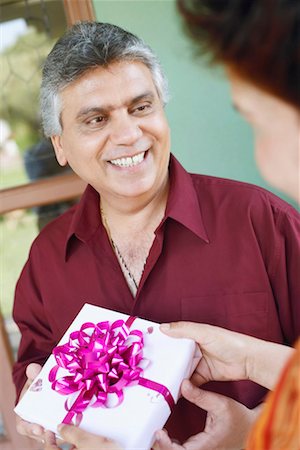retired indian couple - Close-up of a mature woman taking a birthday present from a mature man Foto de stock - Sin royalties Premium, Código: 630-01131105
