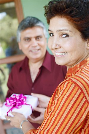 retired indian couple - Close-up of a mature woman taking a birthday present from a mature man Foto de stock - Sin royalties Premium, Código: 630-01131176