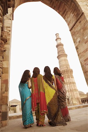 Rear view of four women standing together in front of a monument, Qutub Minar, New Delhi, India Stock Photo - Premium Royalty-Free, Code: 630-01131414