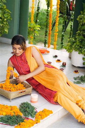 flower decoration in indian wedding - Young woman reclining on the floor and holding a garland Stock Photo - Premium Royalty-Free, Code: 630-01192180