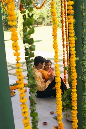 flower decoration in indian wedding - Side profile of a young couple sitting at a doorstep of a house and smiling Stock Photo - Premium Royalty-Free, Code: 630-01192190