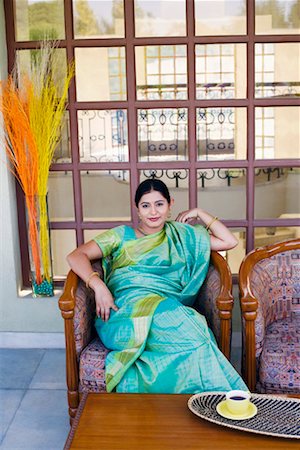 Portrait of a young woman sitting in an armchair Stock Photo - Premium Royalty-Free, Code: 630-01192271