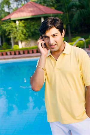 simsearch:630-01079908,k - Young man talking on a mobile phone at the poolside Stock Photo - Premium Royalty-Free, Code: 630-01192342