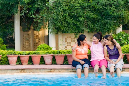 Three young women sitting at the poolside Stock Photo - Premium Royalty-Free, Code: 630-01192365