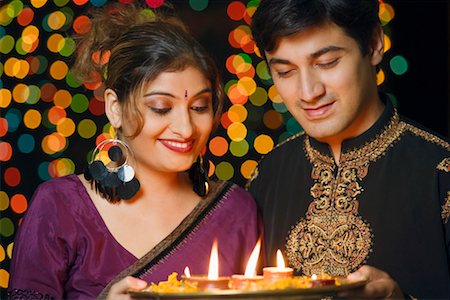 picture of a hindu woman wedding - Close-up of a young couple holding a plate of religious offerings and smiling Stock Photo - Premium Royalty-Free, Code: 630-01192402