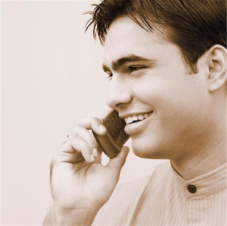 Close-up of a young man talking on a mobile phone Stock Photo - Premium Royalty-Free, Code: 630-01192446