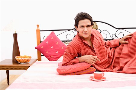 end table lamp - Portrait of a young man lying on the bed Stock Photo - Premium Royalty-Free, Code: 630-01192496