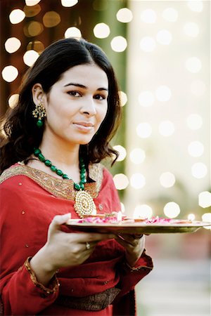 diwali lights photography - Portrait of a young woman holding oil lamps and Rose petals in a plate Stock Photo - Premium Royalty-Free, Code: 630-01192743