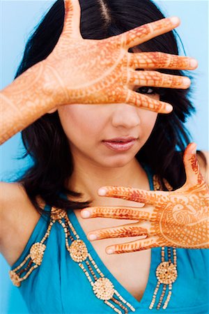 Portrait of a young woman showing henna tattoo on her hands Stock Photo - Premium Royalty-Free, Code: 630-01192794
