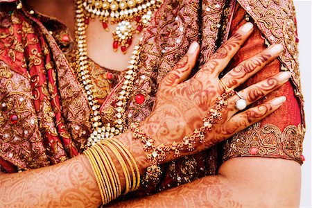 Mid section view of a bride in traditional wedding dress Stock Photo - Premium Royalty-Free, Code: 630-01192920