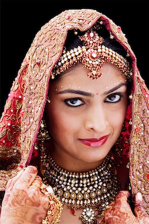 Close-up of a bride in a traditional wedding dress holding a veil Stock Photo - Premium Royalty-Free, Code: 630-01192936