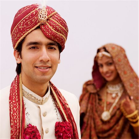 Close-up of a groom smiling with his bride standing behind him Stock Photo - Premium Royalty-Free, Code: 630-01192938