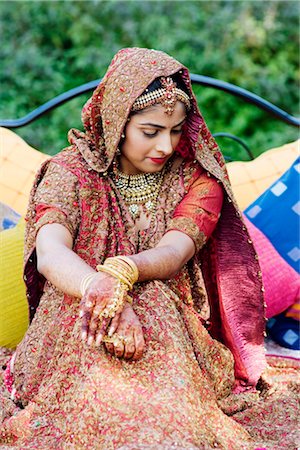 Bride in a traditional wedding dress sitting on the bed in a lawn Stock Photo - Premium Royalty-Free, Code: 630-01192994