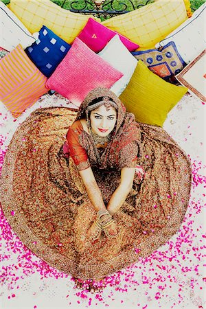 Vue grand angle d'une mariée dans une robe de mariée traditionnelle, allongé sur le lit Photographie de stock - Premium Libres de Droits, Code: 630-01192997