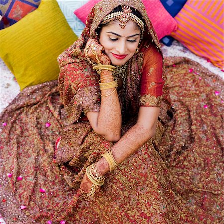 High angle view of a bride in a traditional wedding dress lying on the bed Stock Photo - Premium Royalty-Free, Code: 630-01193001