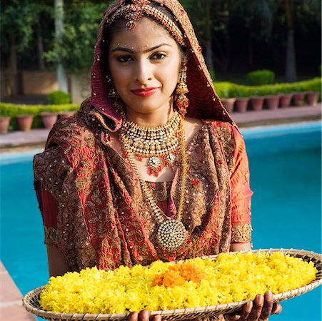 simsearch:630-01192908,k - Portrait of a bride holding a tray of flower garlands in a traditional wedding dress Fotografie stock - Premium Royalty-Free, Codice: 630-01193014