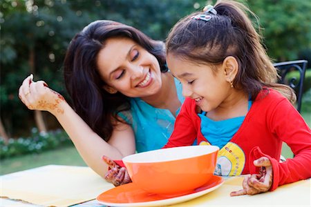 simsearch:655-03457904,k - Mid adult woman with her daughter sitting at a table and smiling Stock Photo - Premium Royalty-Free, Code: 630-01193010