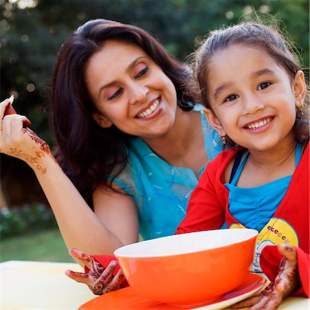 simsearch:655-03457904,k - Mid adult woman with her daughter sitting at a table and smiling Stock Photo - Premium Royalty-Free, Code: 630-01193011