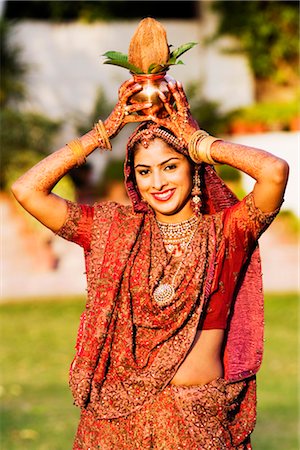 simsearch:630-01192908,k - Portrait of a bride holding a vessel and a coconut on her head Fotografie stock - Premium Royalty-Free, Codice: 630-01193043