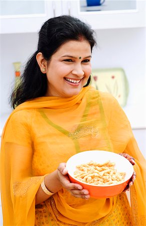 simsearch:655-03457904,k - Mid adult woman holding a bowl of snacks and smiling Stock Photo - Premium Royalty-Free, Code: 630-01296780