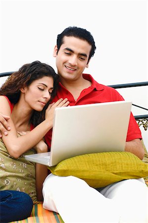 simsearch:640-01356582,k - Young man using a laptop on the bed with a young woman leaning on him Stock Photo - Premium Royalty-Free, Code: 630-01296811