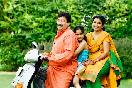 Portrait of a mature man with his wife and daughter riding a motor scooter Stock Photo - Premium Royalty-Free, Code: 630-01296938