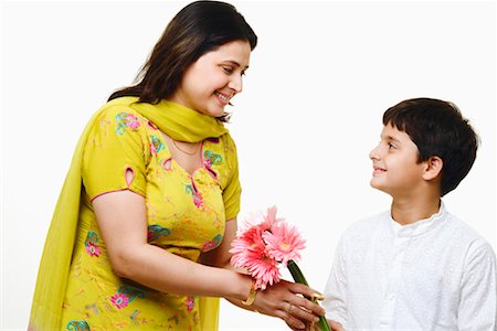 Close-up of a mid adult woman giving a bunch of flowers to her son Stock Photo - Premium Royalty-Free, Code: 630-01297040
