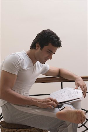 Side profile of a young man reading a newspaper Stock Photo - Premium Royalty-Free, Code: 630-01490461