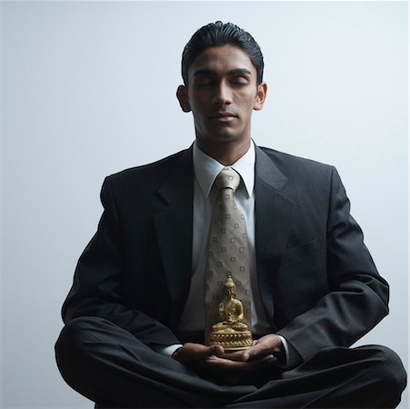 Homme d'affaires méditer à côté d'une statue de Bouddha Photographie de stock - Premium Libres de Droits, Code: 630-01490489