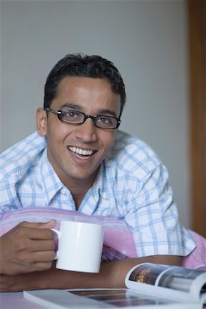 simsearch:630-01872567,k - Portrait of a young man holding a cup of coffee and smiling Foto de stock - Sin royalties Premium, Código: 630-01490496