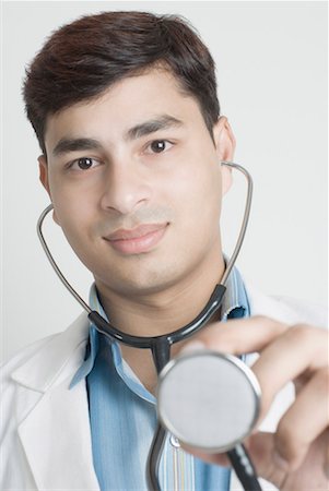 Portrait of a male doctor holding a stethoscope Stock Photo - Premium Royalty-Free, Code: 630-01490491