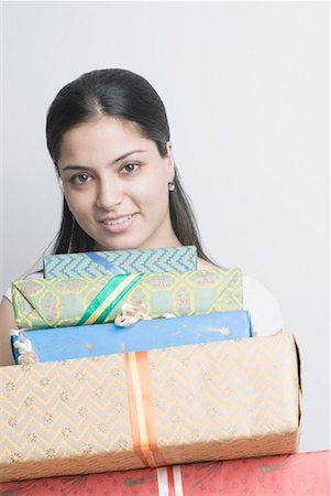 simsearch:630-01491603,k - Portrait of a young woman holding a stack of presents Foto de stock - Sin royalties Premium, Código: 630-01490505