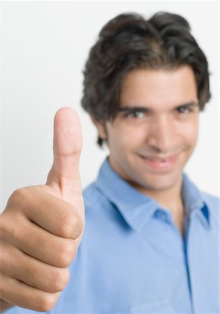 finger up - Portrait of a young man showing thumbs up sign Stock Photo - Premium Royalty-Free, Code: 630-01490517