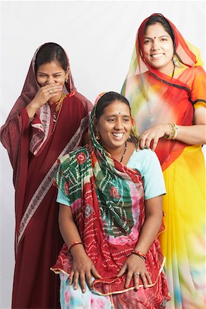 Mid adult woman sitting and two young women standing behind her Stock Photo - Premium Royalty-Free, Code: 630-01490718