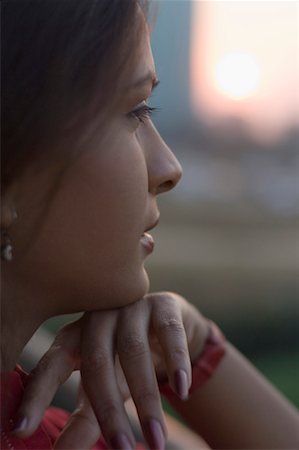 fiore - Side profile of a young woman thinking with her hand on her chin Stock Photo - Premium Royalty-Free, Code: 630-01491031
