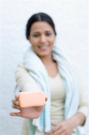 Portrait of a young woman holding a bar of soap Stock Photo - Premium Royalty-Free, Code: 630-01491112