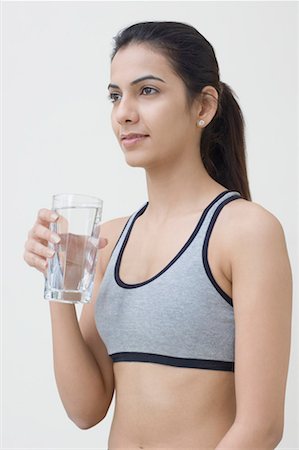 Side profile of a young woman holding a glass of water Stock Photo - Premium Royalty-Free, Code: 630-01491195