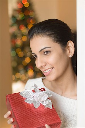 fiore - Close-up of a young woman holding a Christmas present and smiling Stock Photo - Premium Royalty-Free, Code: 630-01491247