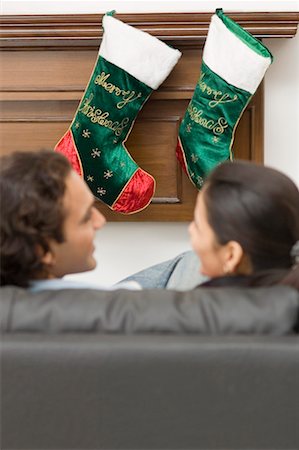 High angle view of a young couple sitting in front of Christmas stockings Stock Photo - Premium Royalty-Free, Code: 630-01491272
