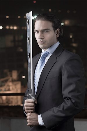 Portrait of a businessman holding a machete Stock Photo - Premium Royalty-Free, Code: 630-01491287