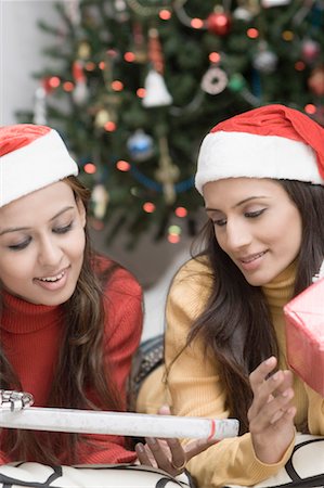 simsearch:853-03616842,k - Deux jeunes femmes portant des chapeaux Santa et tenant de que cadeaux de Noël Photographie de stock - Premium Libres de Droits, Code: 630-01491408