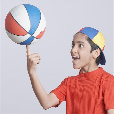 Close-up of a boy spinning a basketball on his finger Stock Photo - Premium Royalty-Free, Code: 630-01491546