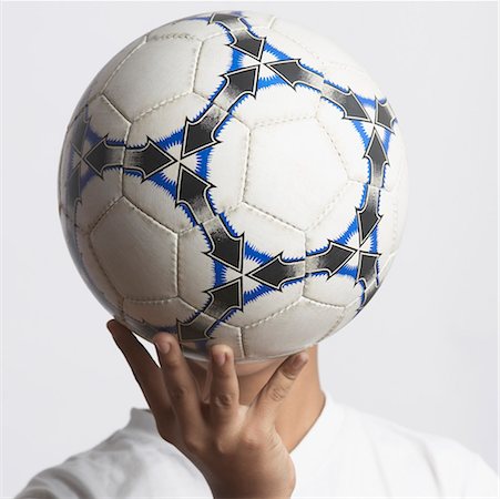 Gros plan d'un garçon qui couvre son visage avec un ballon de soccer Photographie de stock - Premium Libres de Droits, Code: 630-01491565