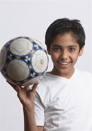 preteen boy happy white background - Portrait d'un garçon tenant un ballon de soccer Photographie de stock - Premium Libres de Droits, Code: 630-01491563