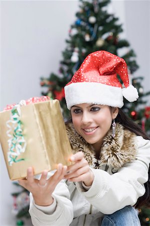 Young woman holding a gift and smiling Foto de stock - Sin royalties Premium, Código: 630-01491640