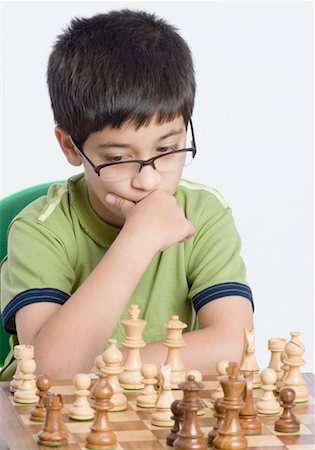 Close-up of a boy playing chess with his hand on his chin Foto de stock - Sin royalties Premium, Código: 630-01491701